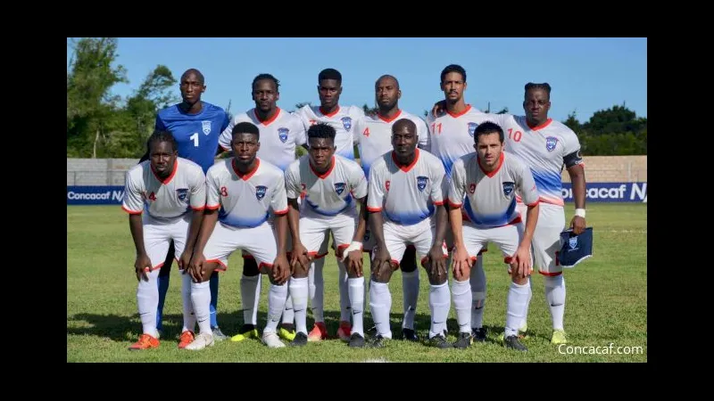 Cầu thủ đội Sint Maarten nỗ lực ngăn chặn cầu thủ đội Dominica.